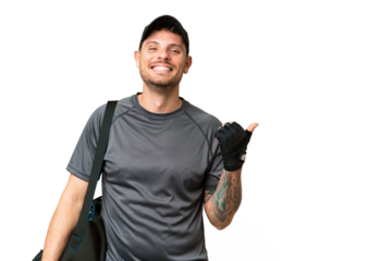 Young sport man with sport bag over isolated chroma key background pointing to the side to present a product