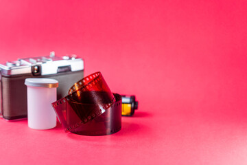 Vintage Camera and Film Roll on Pink Background