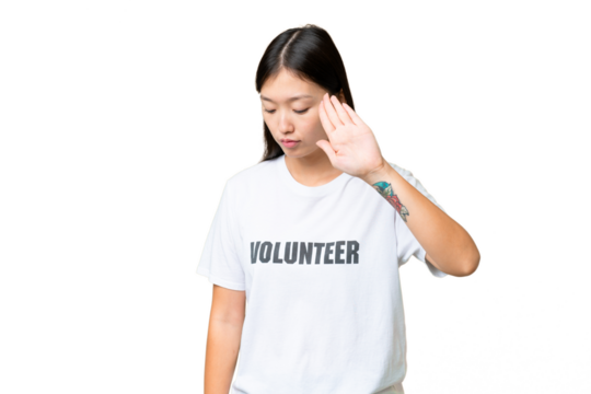 Young volunteer woman over isolated chroma key background making stop gesture and disappointed