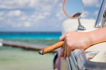 female hand with cuban cigar, woman, cuban cigar day, cuban flag, manicure, cuban flag on nail,	
couple sitting in car by turquoise ocean, trip to cuba, honeymoon