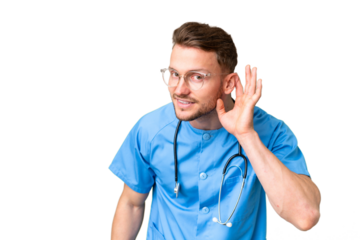 Young nurse man over isolated chroma key background listening to something by putting hand on the ear