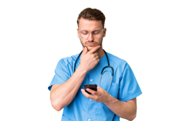 Young nurse man over isolated chroma key background thinking and sending a message