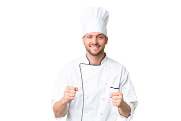 Young caucasian chef over isolated chroma key background celebrating a victory in winner position