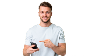 Young handsome caucasian man over isolated chroma key background using mobile phone and pointing it