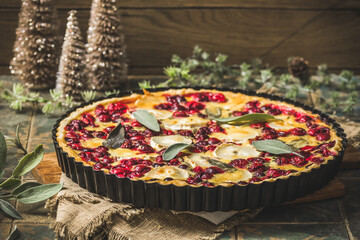 Cranberry goat cheese tart with sage on rustic blue background