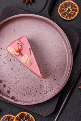 Piece of sweet cheesecake with pink cream cheese of raspberry or strawberry flavor