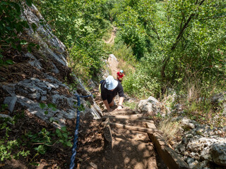 Obraz premium Tourist on wooden stairs on the trail to Inelet and Scarisoara hamlets, Romania