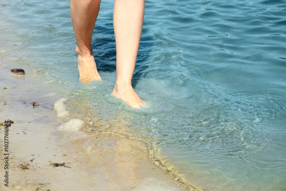 Canvas Prints Woman walking barefoot through water on riverbank, closeup