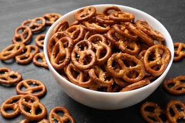 Delicious pretzel crackers on black table, closeup