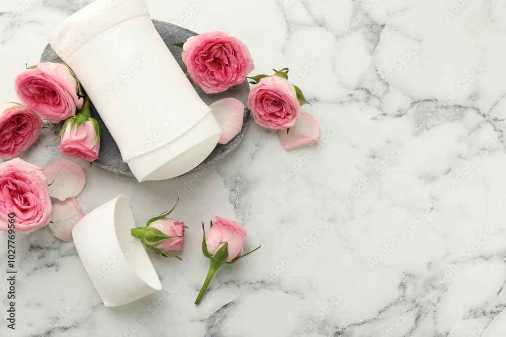 Wall mural Solid deodorant and beautiful rose flowers on white marble table, flat lay. Space for text