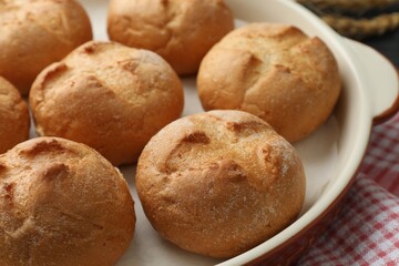Baking dish with homemade tasty buns on table, closeup