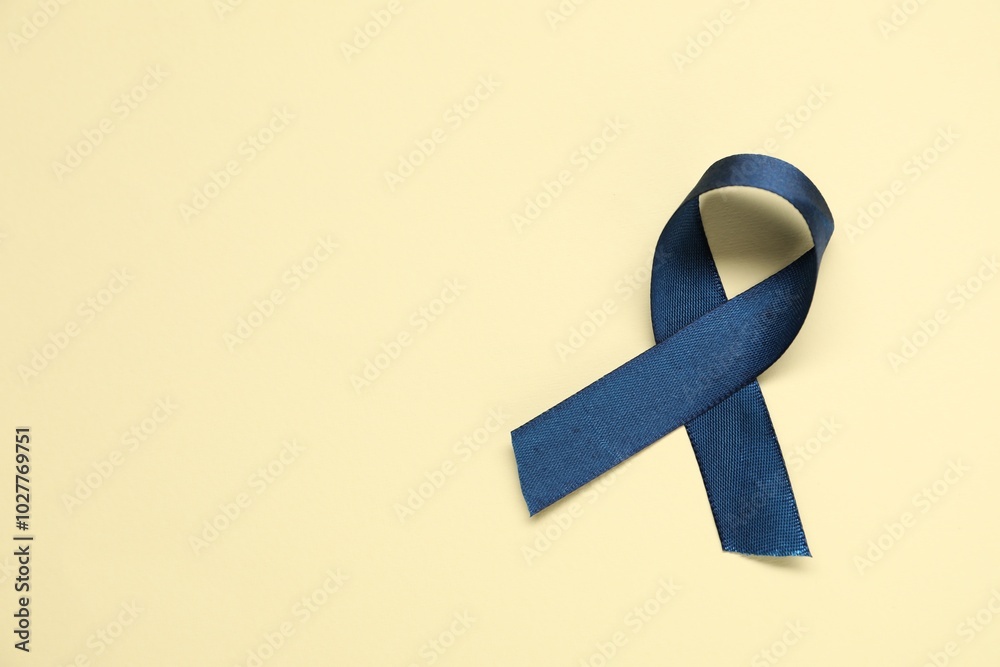 Poster Blue awareness ribbon on yellow background, top view. Space for text