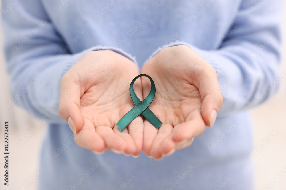 Poster Woman with teal ribbon on light background, closeup. Ovarian cancer and gynecological disorders awareness