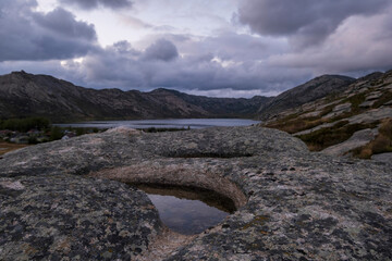Beautiful rocky and layered mountains with small lakes in Eastern Kazakhstan near Sibinsky Lakes under a gloomy autumn sky.