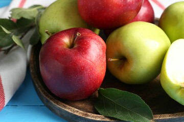Fresh red and green apples on light blue wooden table, closeup