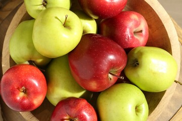 Ripe red and green apples in bowl on table, top view