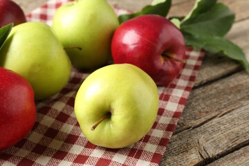 Ripe red and green apples on wooden table, closeup