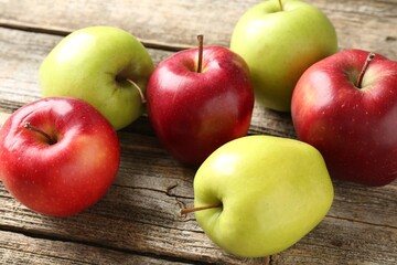 Ripe red and green apples on wooden table, closeup