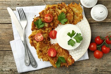 Delicious potato pancakes served on wooden table, flat lay