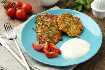 Delicious potato pancakes served on wooden table, closeup
