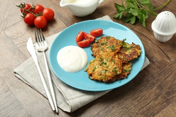 Delicious potato pancakes served on wooden table, closeup