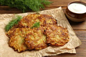 Delicious potato pancakes served on wooden table, closeup