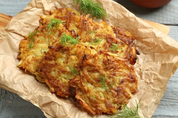 Delicious potato pancakes with dill on grey wooden table, closeup