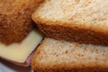 slices of bread with cheese and ham. background of bread with ham and cheese. food details.
