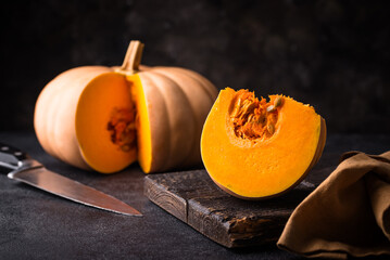 Raw fresh cut pumpkin on dark background