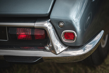 Fototapeta premium Rear light and a chrome bumper of a old french car on a classic car show.