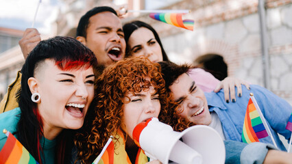 Gay people celebrating pride festival party with rainbow flags together. Diverse friends at LGBTQ...