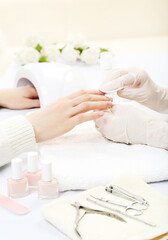 Manicurist making manicure for client in salon