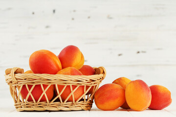 Sweet apricots in basket on white background
