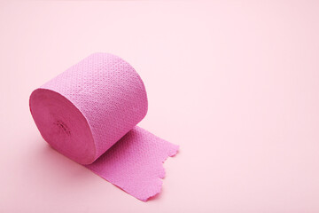 Roll of toilet paper on pink background