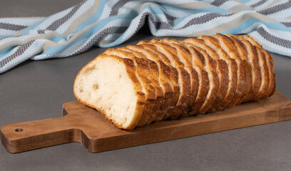 Fresh white loaf of bread on gray