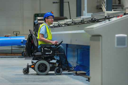 Production line engineer with disability in a factory with yellow vest and blue helmet at work.