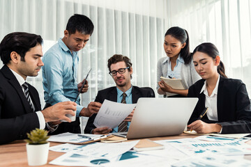 Diverse group of business analyst team analyzing financial data report paper on office table. Chart and graph dashboard by business intelligence analysis for strategic marketing planning Meticulous