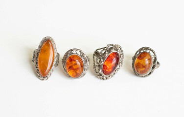 Collection of Vintage Amber Stone Rings – Flatlay on White Background with Soft Lighting