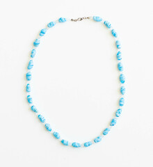 Obraz premium Blue Glass Bead Necklace – Boho Style Jewelry Flatlay on White Background