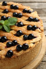 Delicious homemade blueberry pie with mint on table, closeup