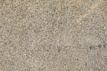 A close up of a stone surface with a lot of texture. The stone is a mix of gray and brown colors