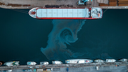 Aerial photo of the cargo ship in a canal with oil spill on the water around, Brighton and Hove, East Sussex, UK