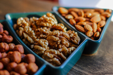different types of nuts, Various snacks for the New Year table in a plate in the shape of a Christmas tree.
