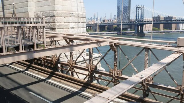 Cars on Brooklyn Bridge, New York City Midtown and Manhattan Bridge view. Green boro taxi cab, road traffic and architecture. Iconic landmark on East River. Travel USA.