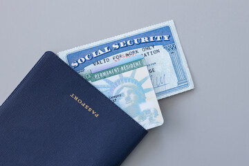United States passport, social security card and permanent resident (green) card on white...