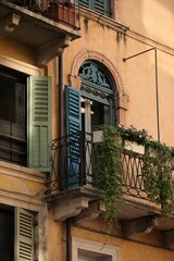Balcony terrace with flowers, old building in Italy