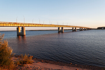 Fototapeta premium Large bridge across the Northern Dvina River in Arkhangelsk city at sunset. Summer time