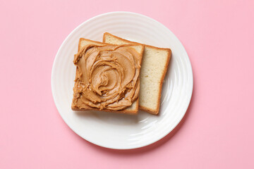 Delicious sandwich with peanut butter on pink table, top view