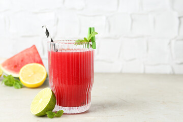 Delicious watermelon drink in glass and fresh fruits on light table. Space for text