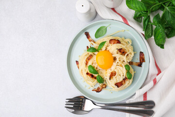 Delicious pasta Carbonara served on light gray table, flat lay. Space for text